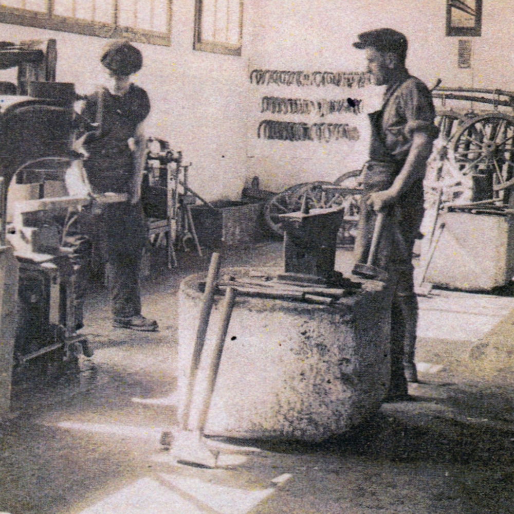 Fotografie 1933. Einblick in die Schmiede. Rechts am Amboss: Peter Raimund Steiner Links am Federhammer: Geselle Paul
