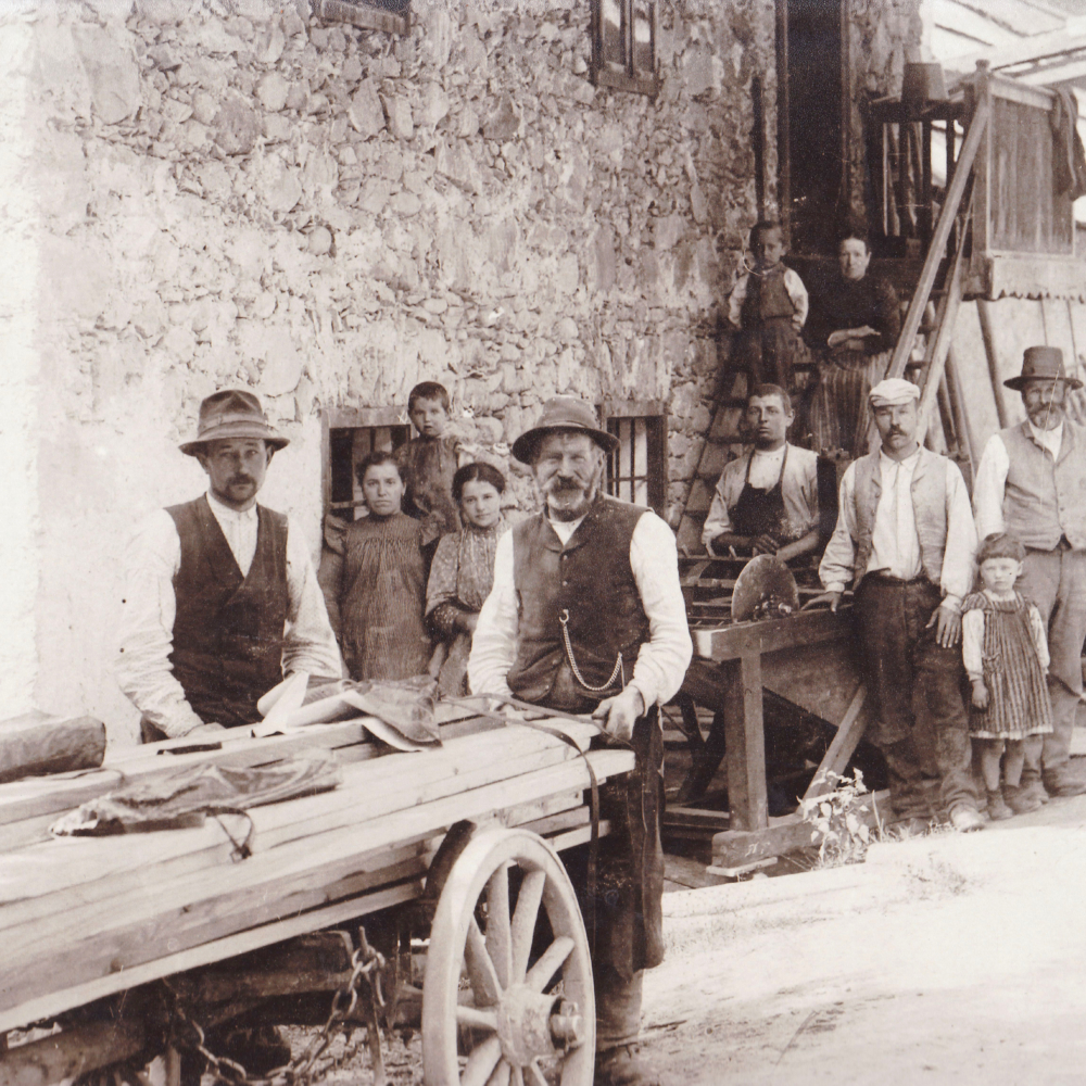 Fotografie um 1900 Arbeiter vor der alten Schmiede, Straßenseite mit Treppenaufgang. Dahinter die Werkstatt mit Ochsenstand.